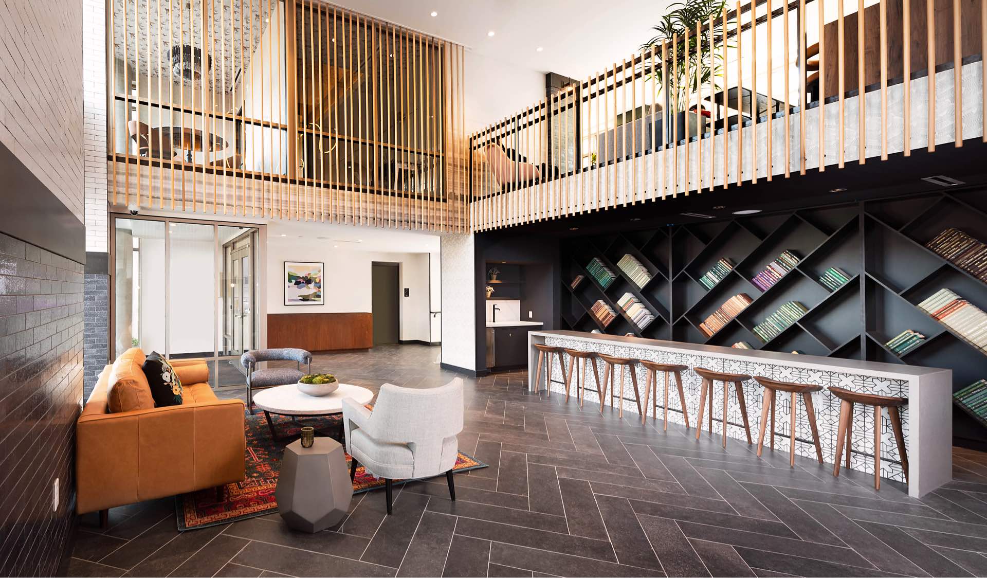 Faraday Park East community lounge with bar, book wall, comfortable seating, and designer finishes